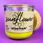 Recycled glass candle with sunflower label, yellow wax, and clear glass jar