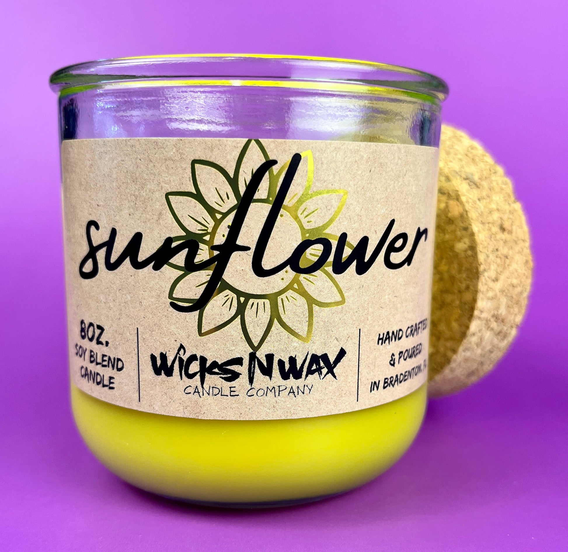 Recycled glass candle with sunflower label, yellow wax, and clear glass jar
