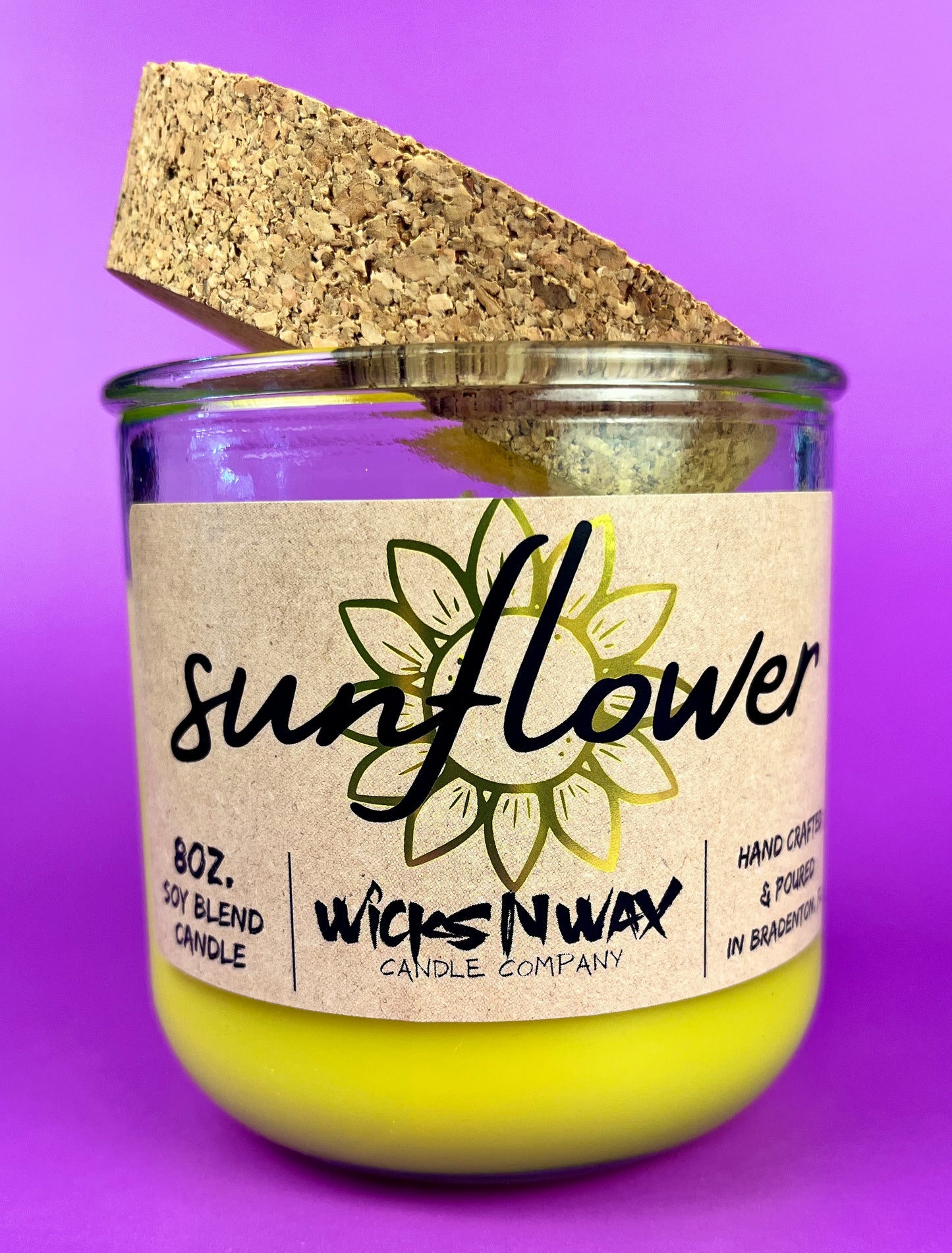 Recycled glass candle with sunflower label and yellow wax, cork lid tilted
