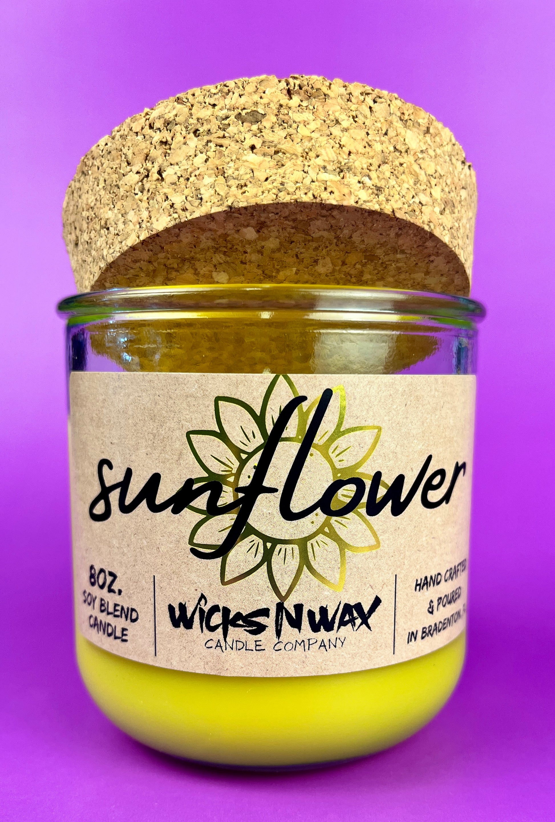 Recycled glass candle with sunflower label, yellow wax, and cork lid