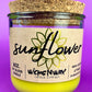 Recycled glass candle with sunflower label and yellow wax in clear jar
