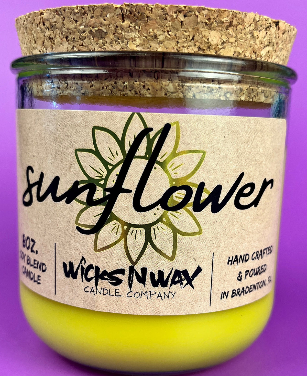 Recycled glass candle with sunflower label, yellow jar, and cork lid, WicksNWax