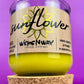 Recycled glass candle with sunflower label and yellow wax, cork base visible