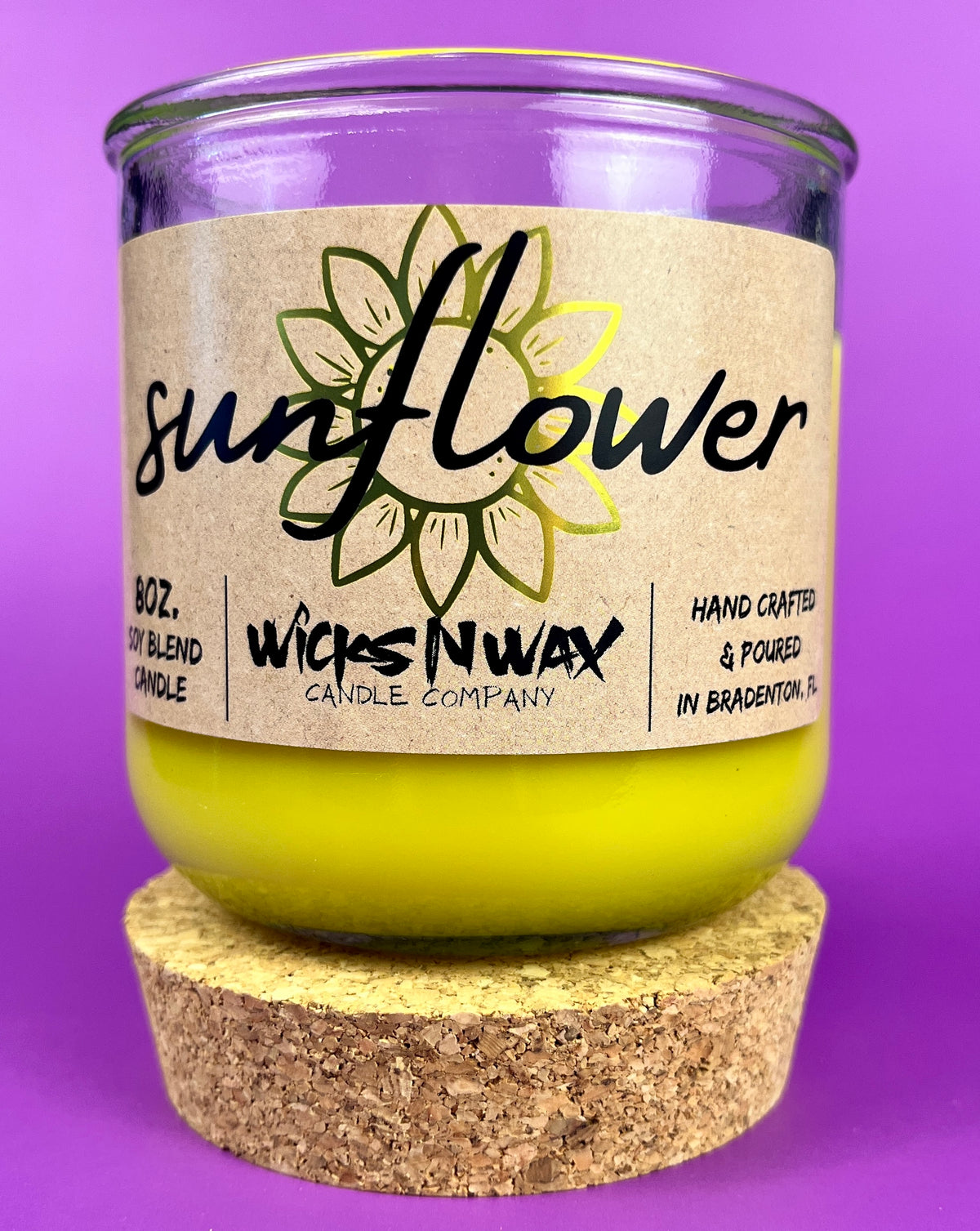 Recycled glass candle with sunflower label on beige wrap and yellow wax