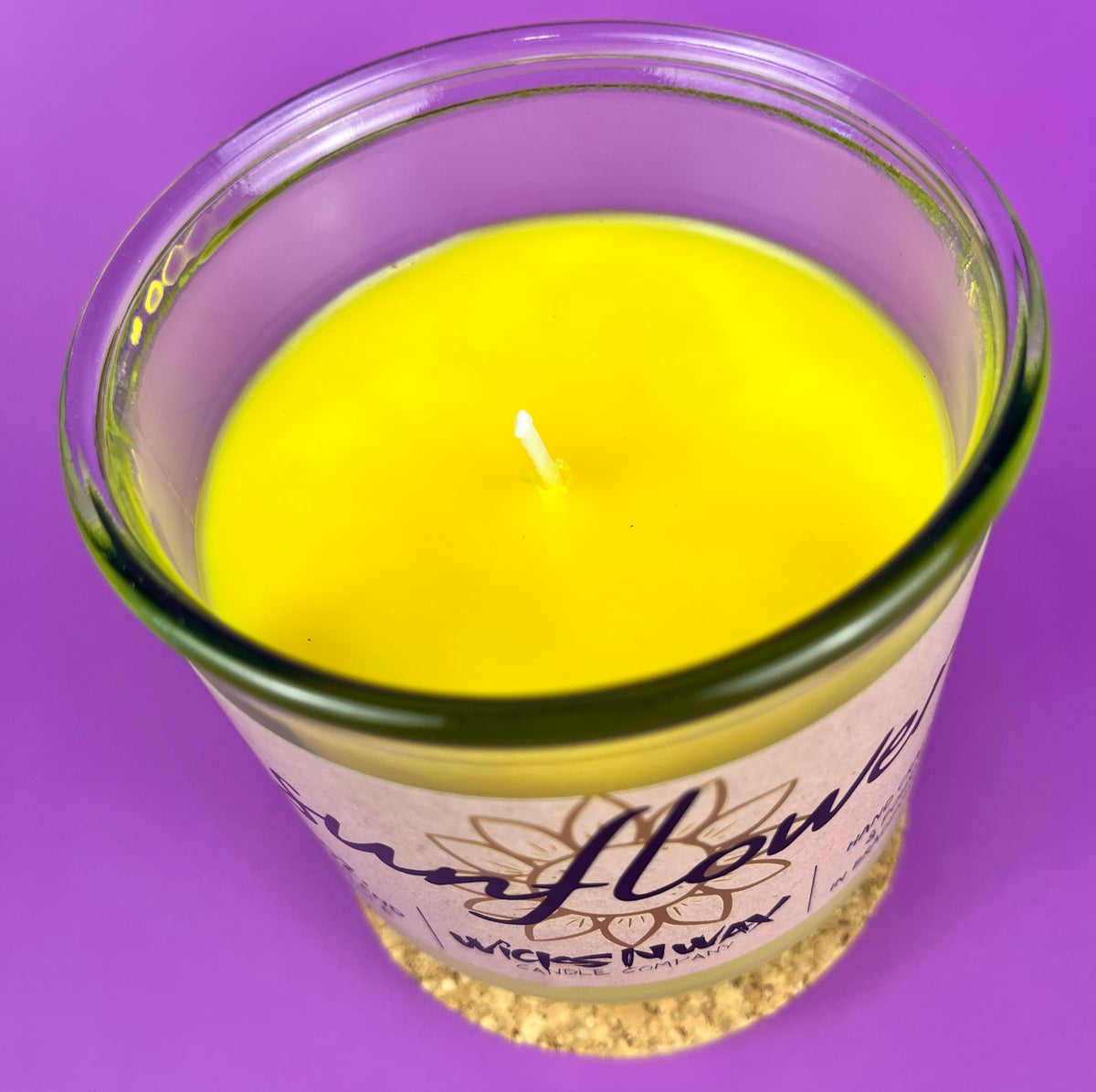 Recycled glass candle close-up of yellow wax and wick in clear jar