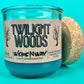 Blue glass candle jar with cork lid partially removed, Twilight Woods label
