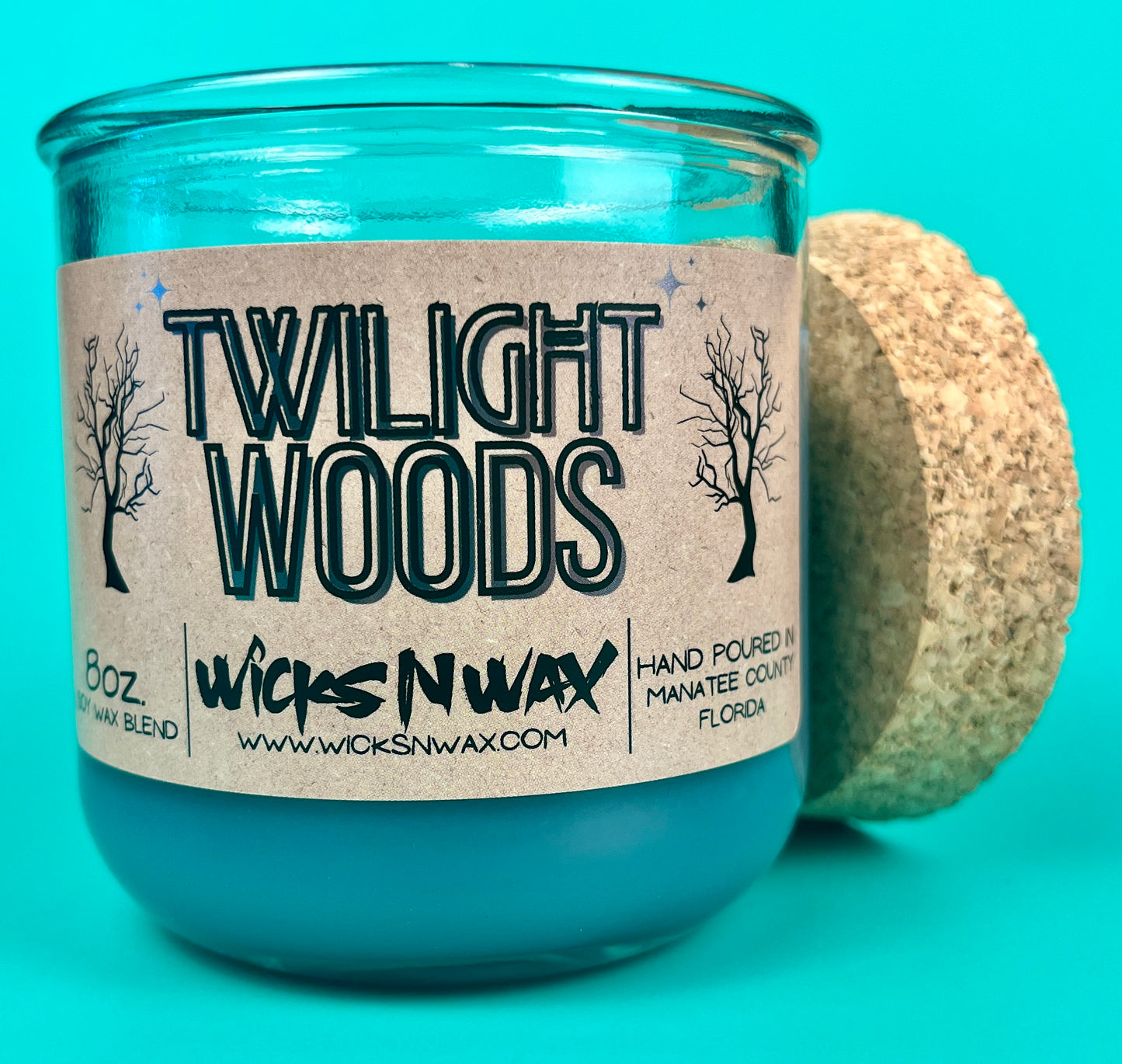 Blue glass candle jar with cork lid partially removed, Twilight Woods label