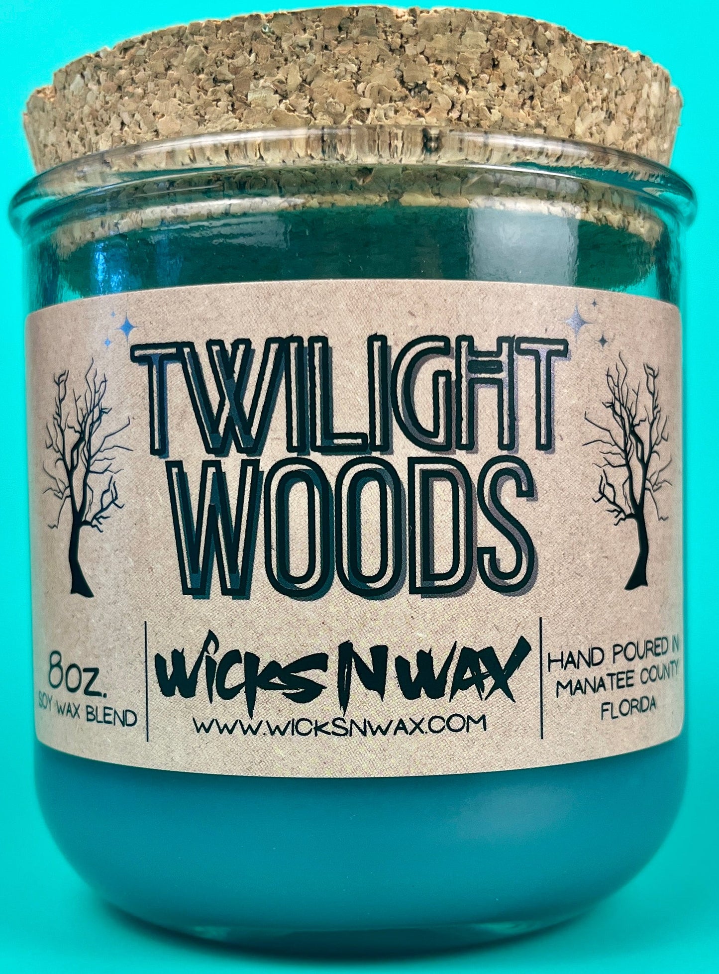 Recycled glass candle in teal jar with WicksNWax Twilight Woods label