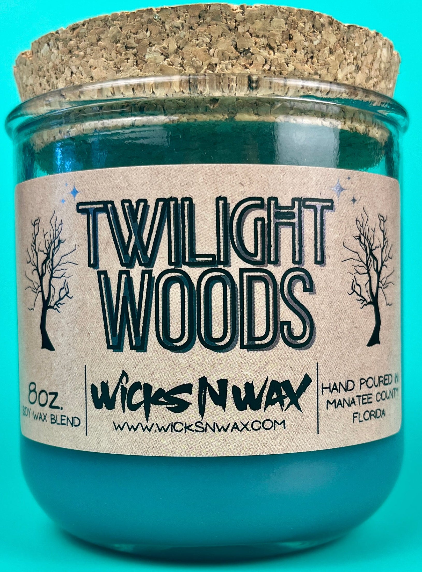 Recycled glass candle in teal jar with WicksNWax Twilight Woods label