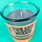 Blue glass candle jar with wick visible and Twilight Woods label on front