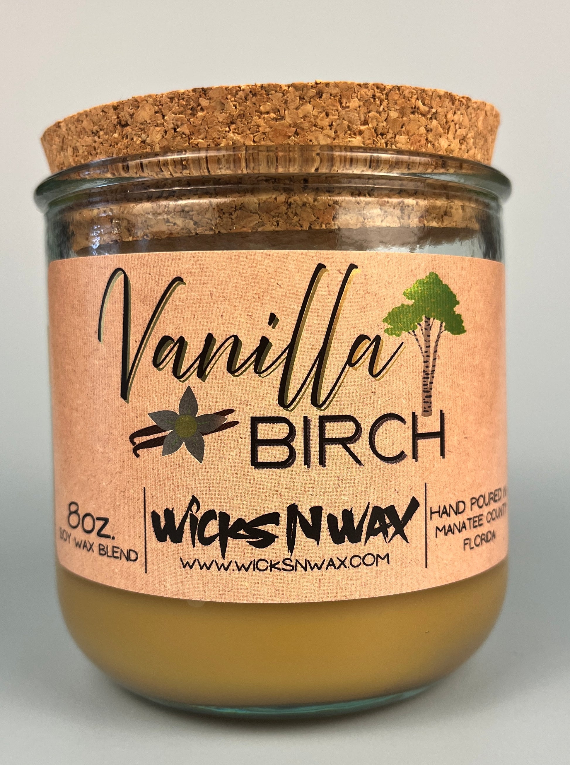 Vanilla Birch recycled glass candle with tan wax, clear glass jar, and cork lid