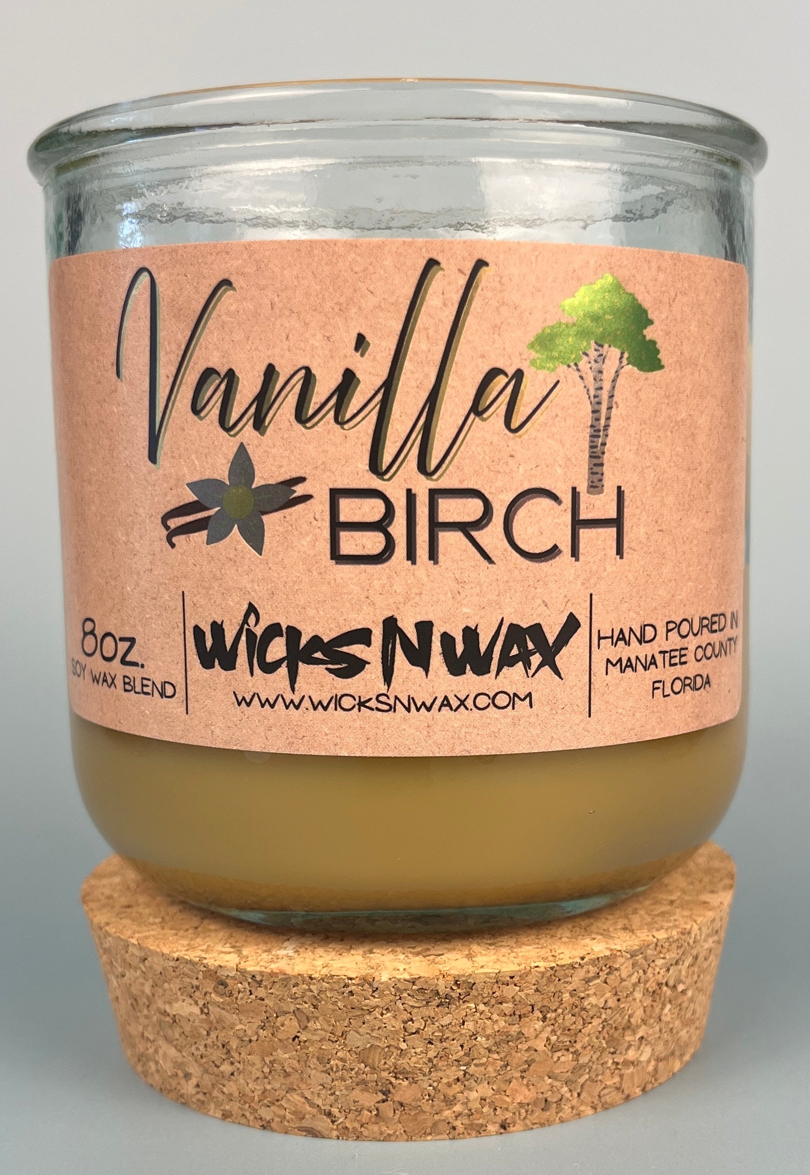 Vanilla Birch recycled glass candle in clear jar with tan wax and cork base, kraft label