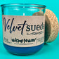 Teal glass candle jar with kraft label, cork lid, and centered wick