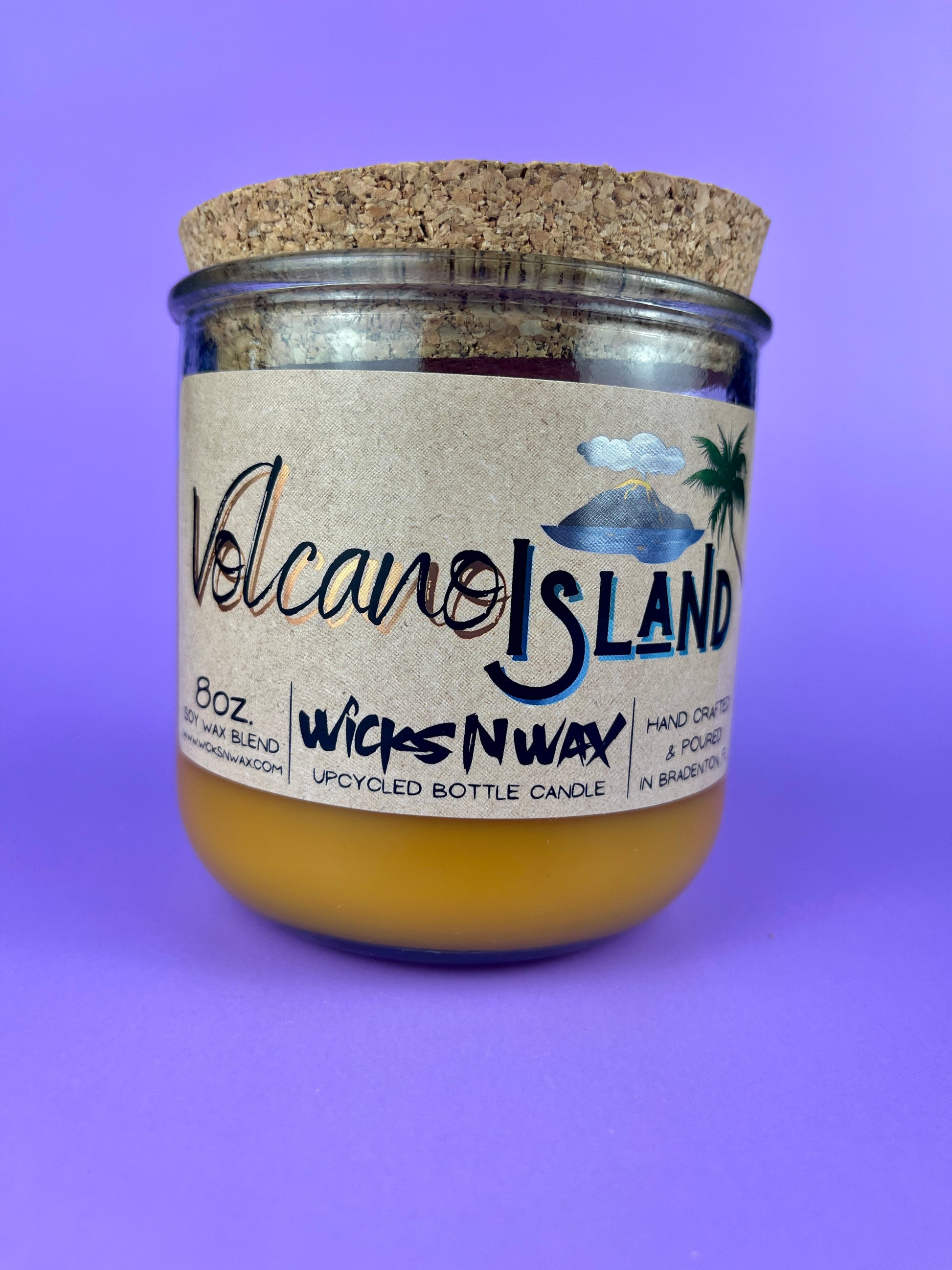 Recycled glass candle jar with Volcano Island label and yellow wax, cork base