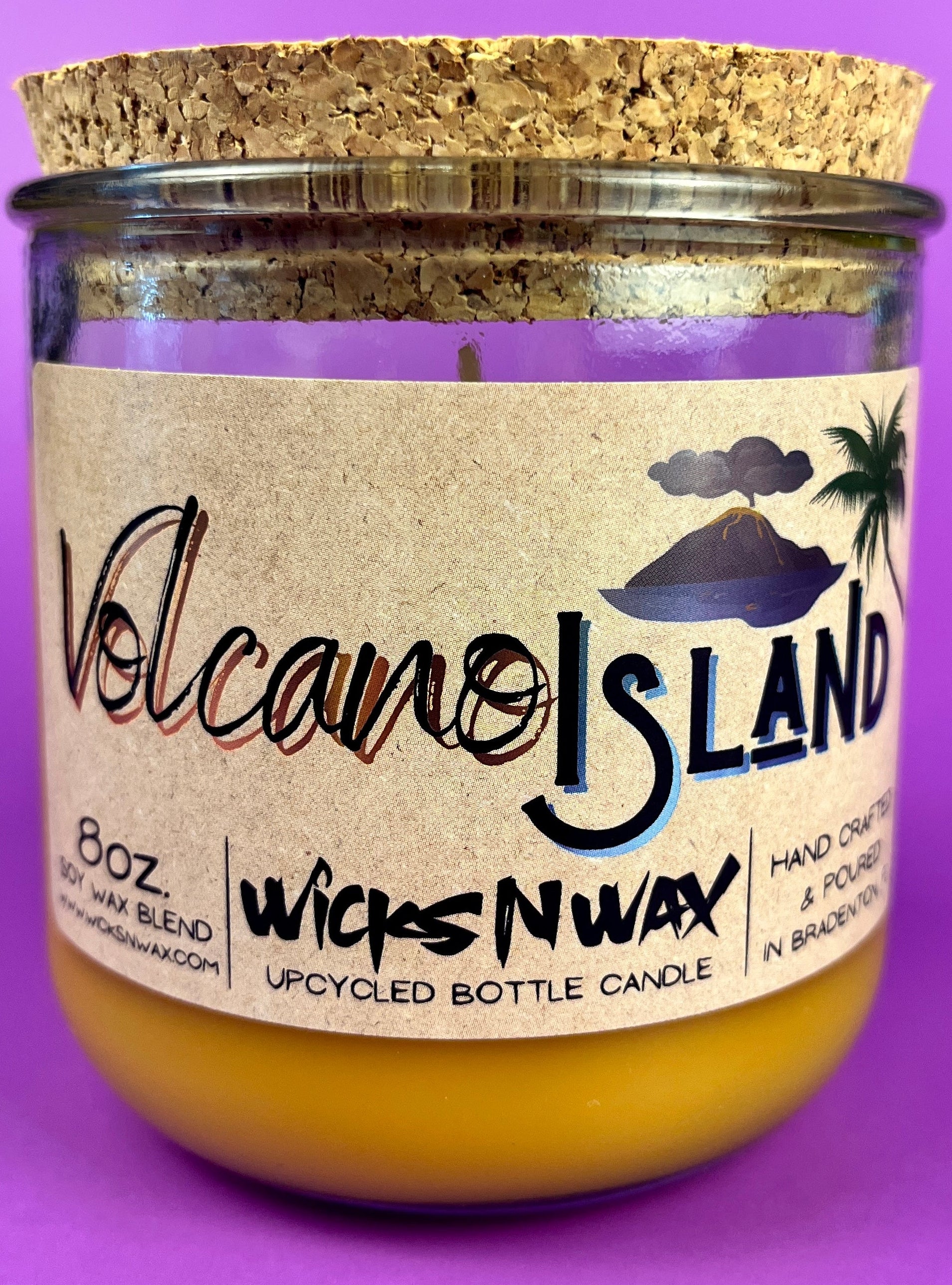 Recycled glass bottle candle in amber wax with Volcano Island WicksNWax label