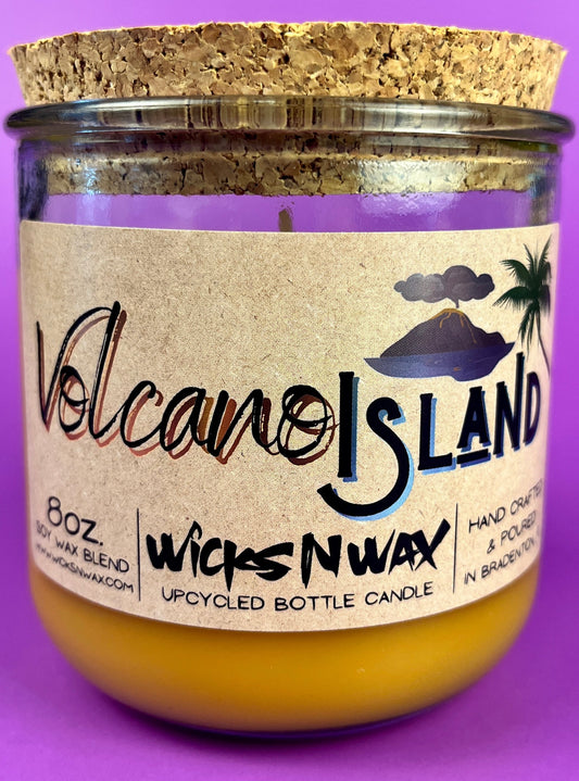 Recycled glass bottle candle in amber wax with Volcano Island WicksNWax label