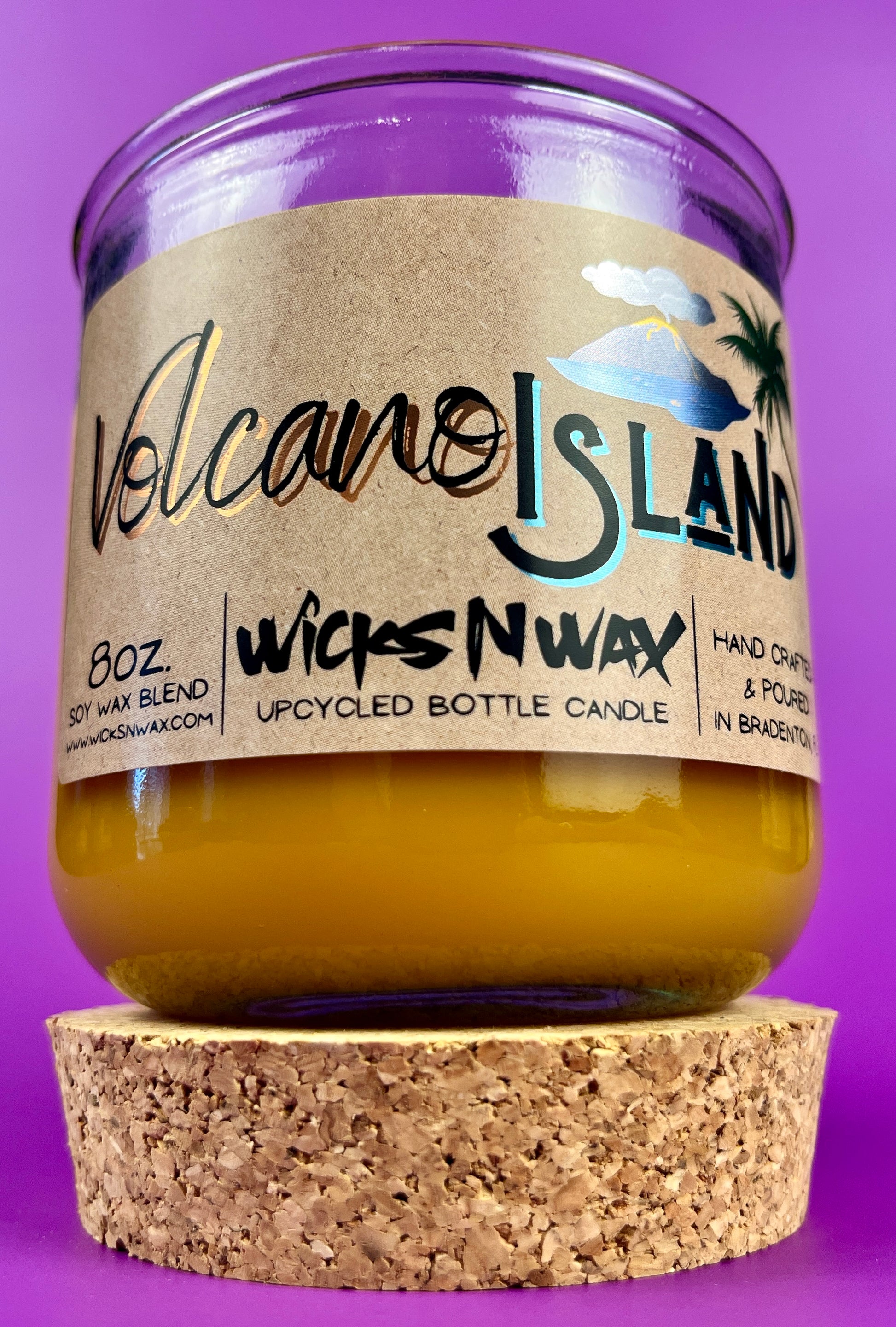 Recycled glass candle jar with Volcano Island label and yellow wax, cork base