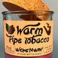 Glass bottle candle with red wax, leaf-and-smoke graphic label, with cork lid