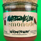 Glass candle jar with red wax and dark label text for watermelon lemonade, cork base