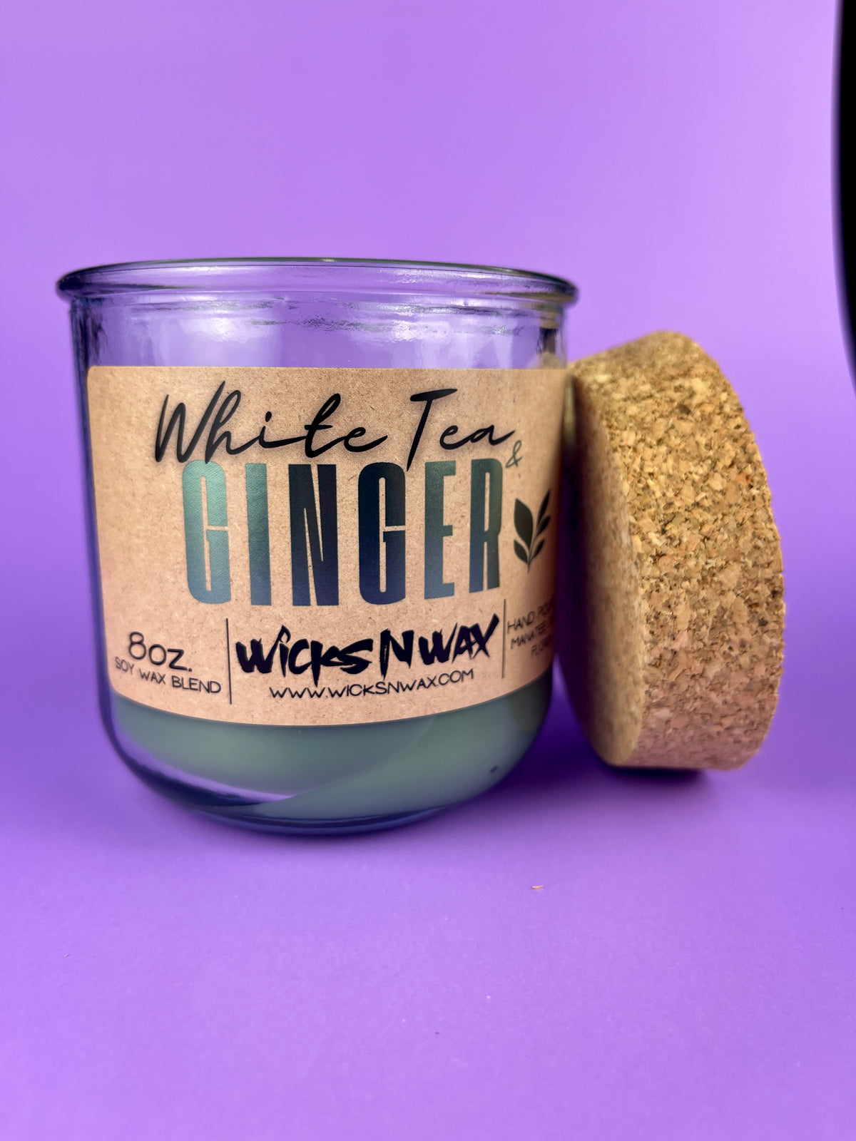 Recycled glass candle jar with cork end piece beside it, White Tea & Ginger label.