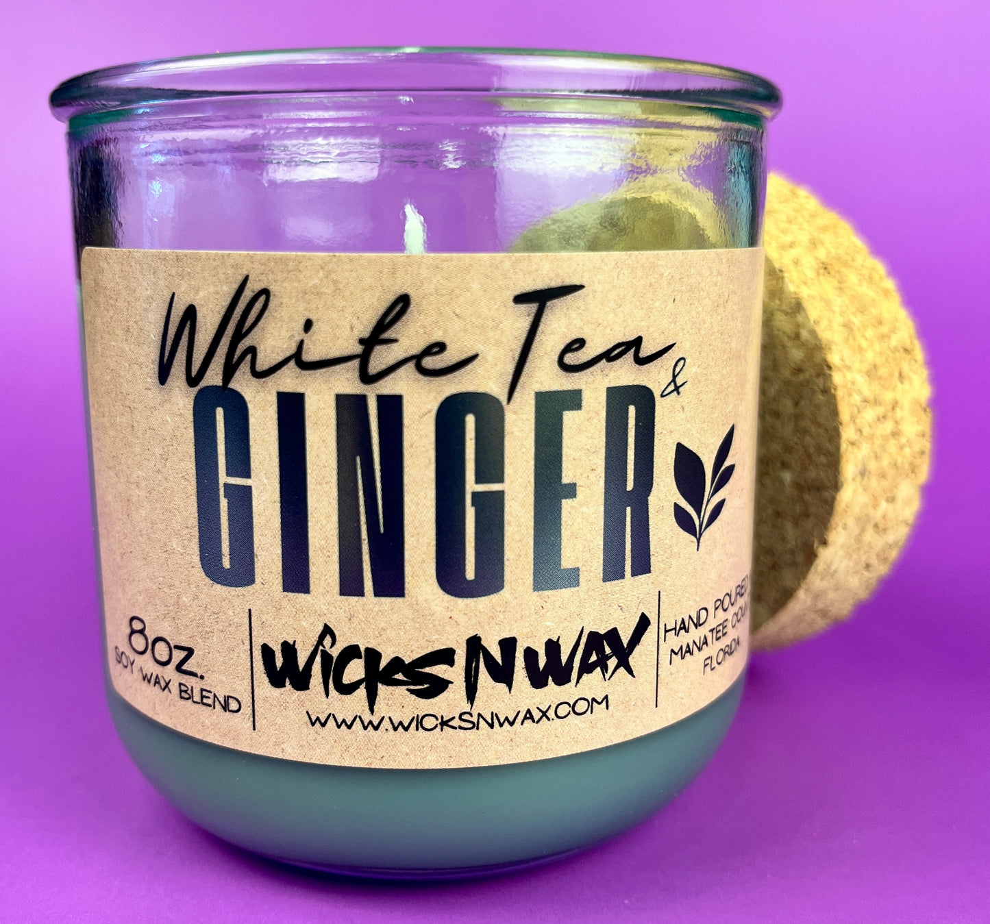 Recycled glass candle jar with cork end piece behind, White Tea & Ginger label.