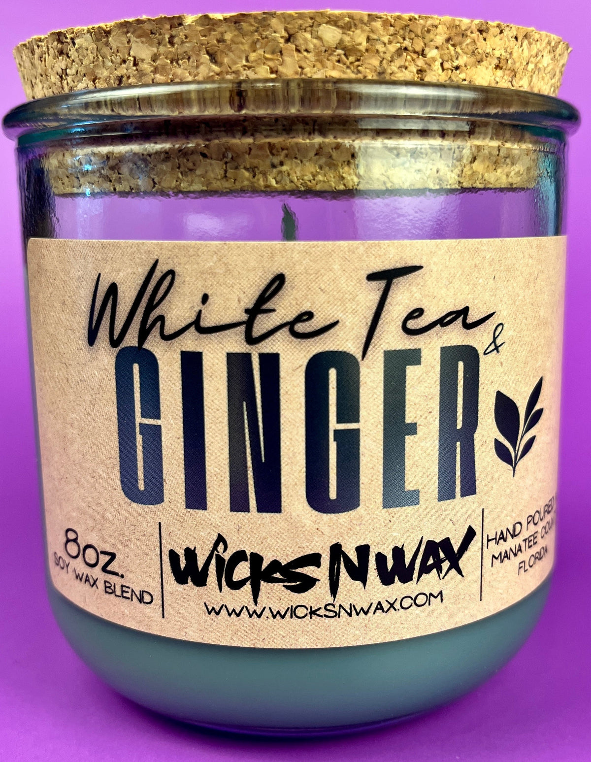 Recycled glass candle in clear jar with beige label reading 'White Tea & Ginger'