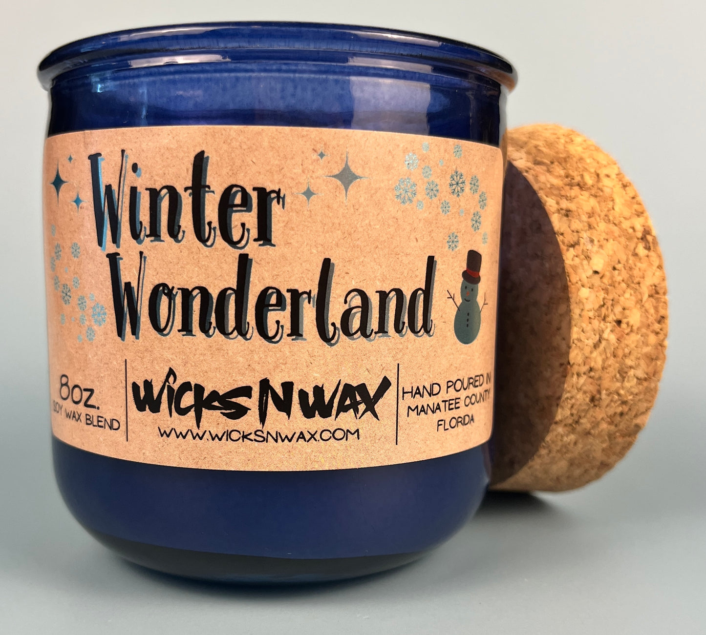 Blue glass candle with cork and side label, jar and lid shown