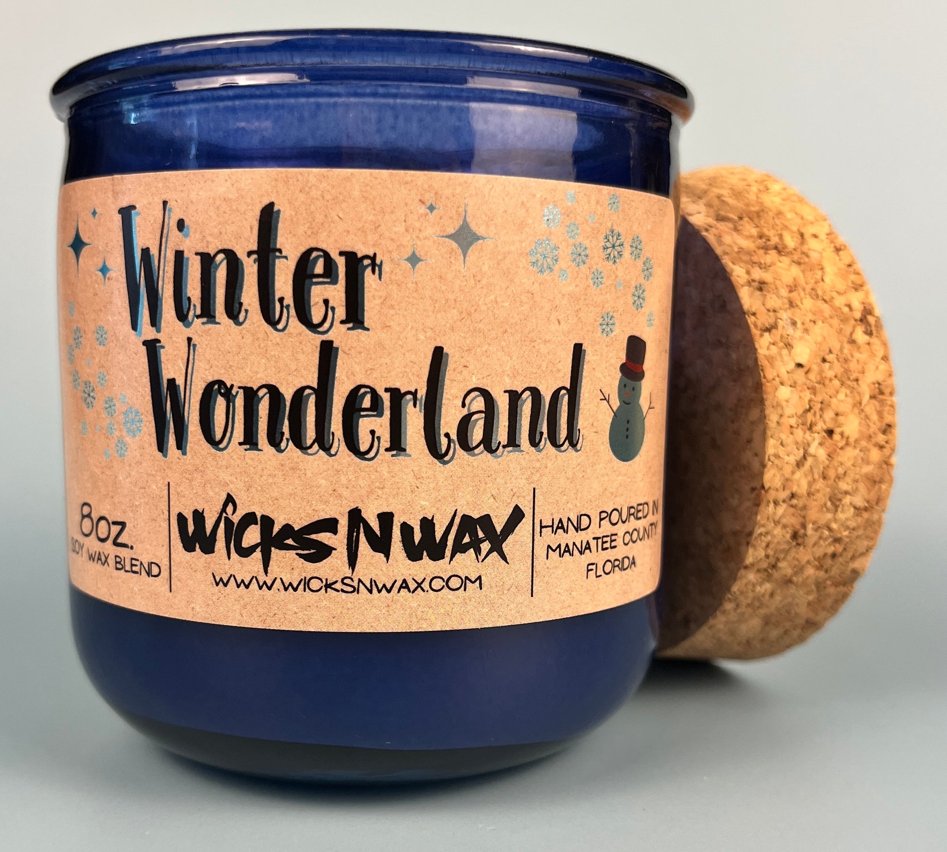 Blue glass candle with cork and side label, jar and lid shown
