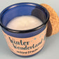 Blue glass candle with white wax pool and wick, Winter Wonderland label