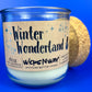 Recycled glass candle jar with Winter Wonderland label on side and cork base